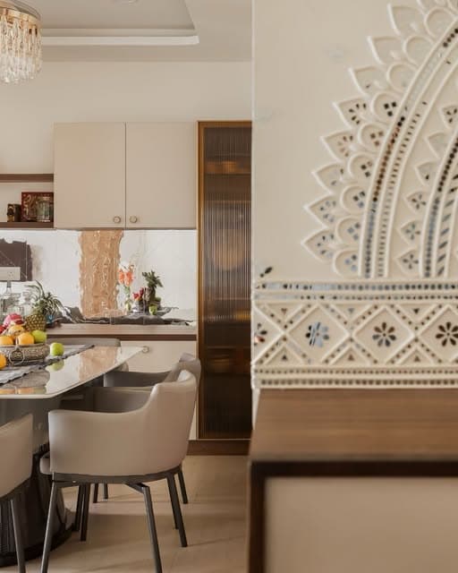 An intricate white screen frames a glimpse of the dining area, bringing pattern and depth to the threshold.