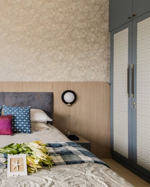Patterned wardrobe panels, a warm headboard and textured bedding bring a rich yet restful rhythm to the bedroom.