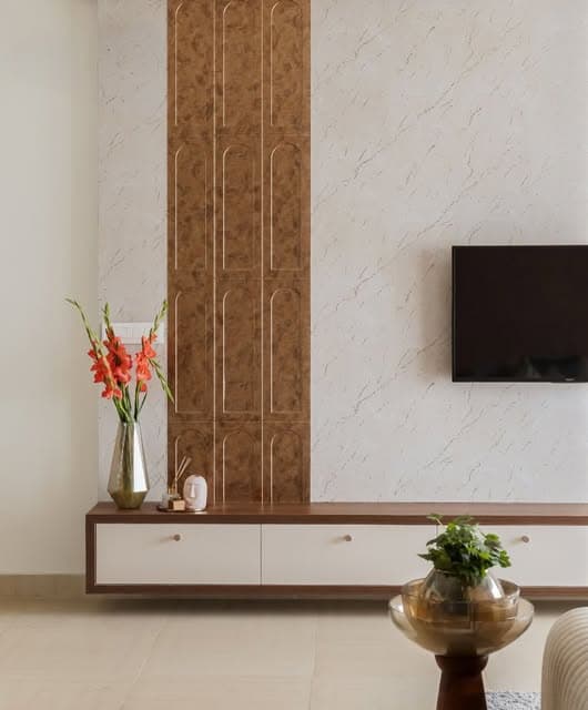 A pale textured wall meets a warm decorative panel, with a floating console keeping the composition light.