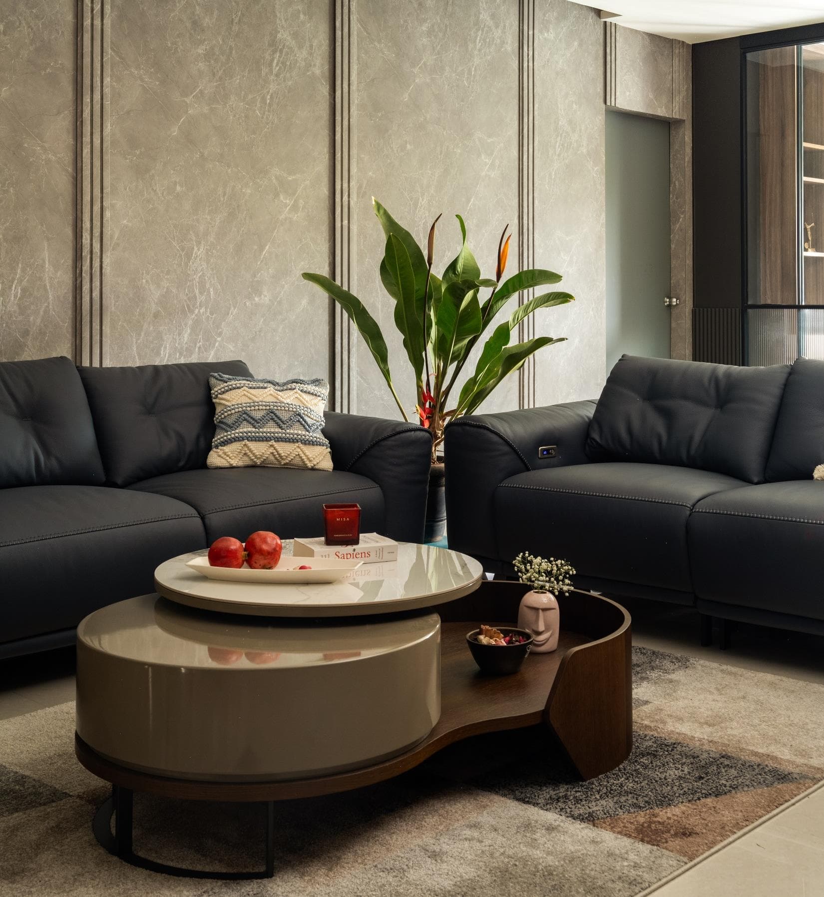 Living room with a neutral sectional sofa, textured rug and warm wood accent wall